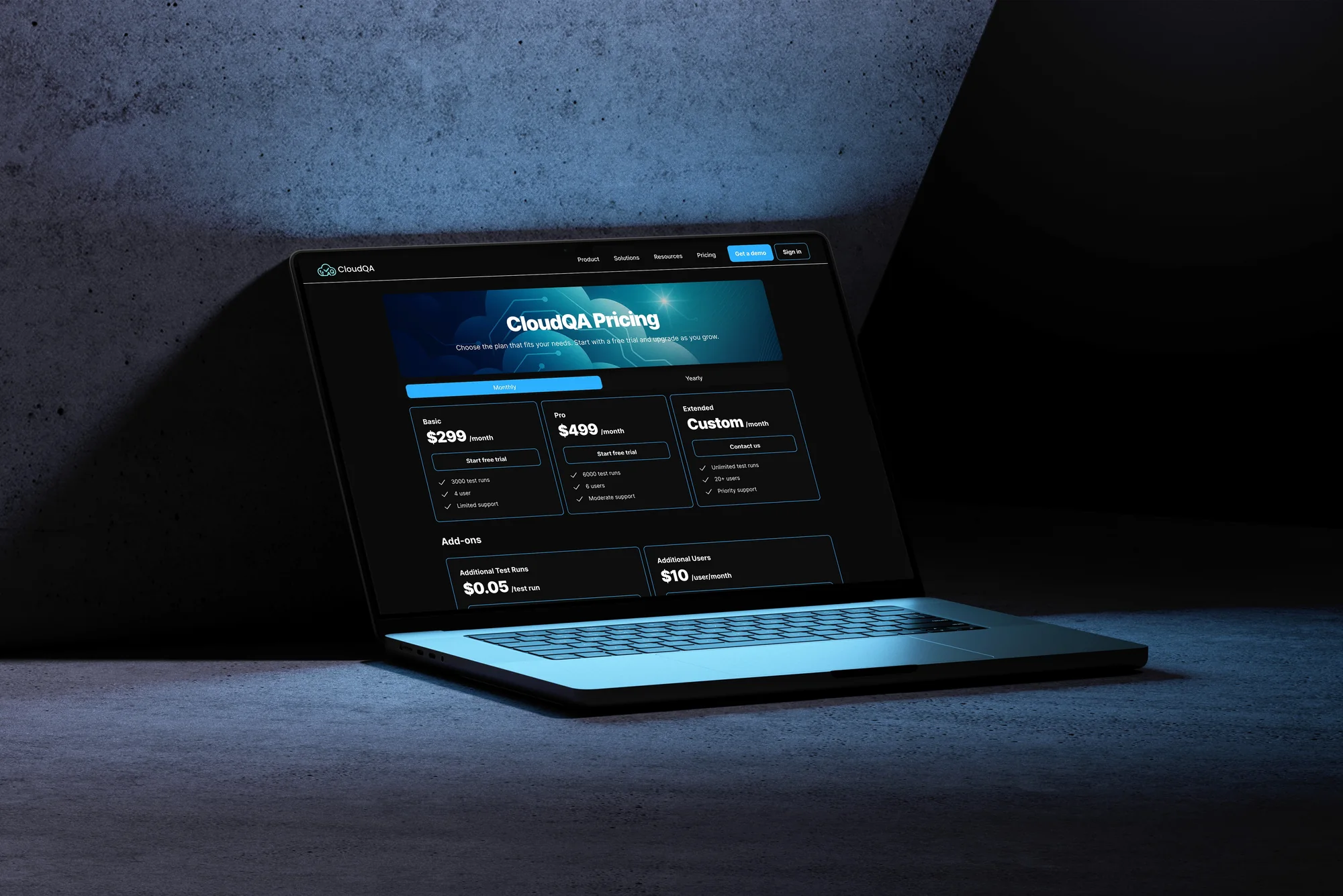 The CloudQA pricing page shown on a laptop in a dark studio setting
